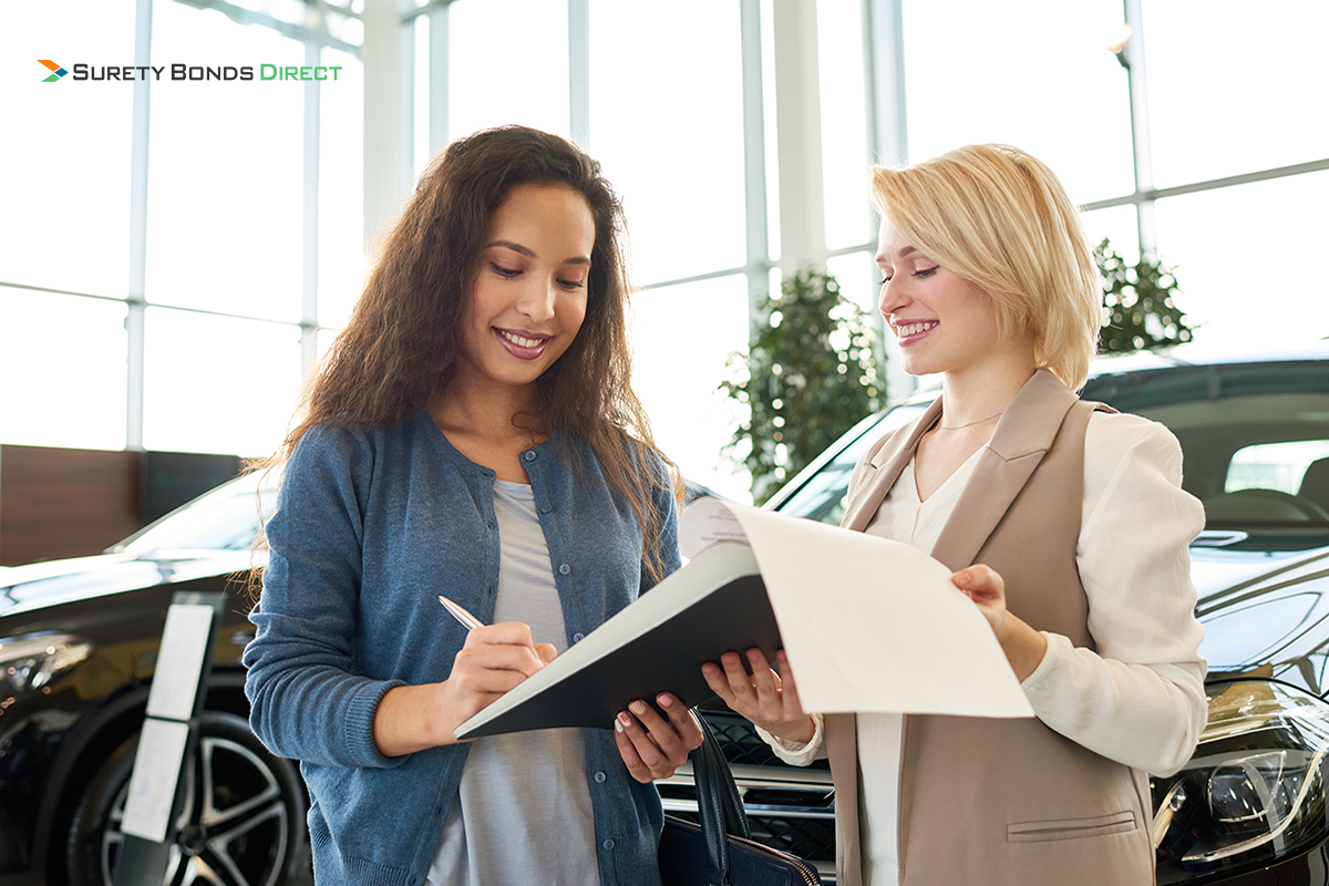 Woman at dealership signing contracts